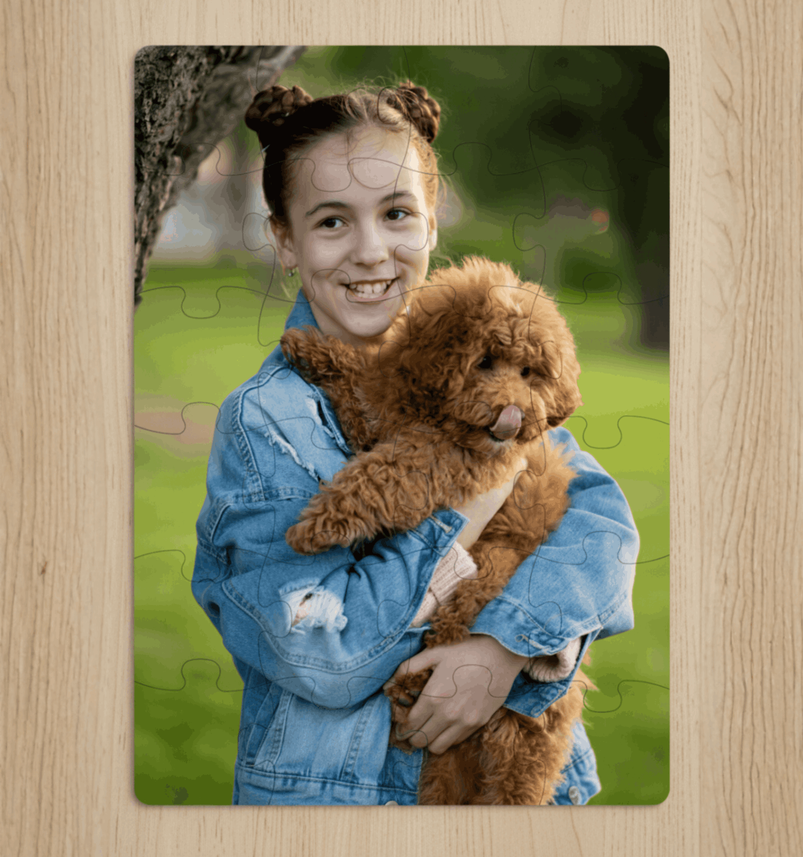 Jigsaw puzzle with a picture of a girl holding a brown dog on a wooden surface