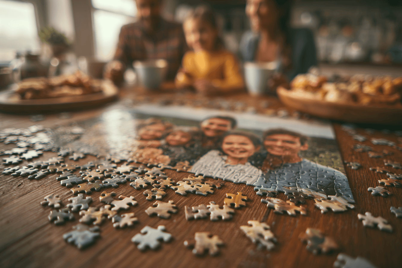 Family photo puzzle on a table with a blurred family in the background